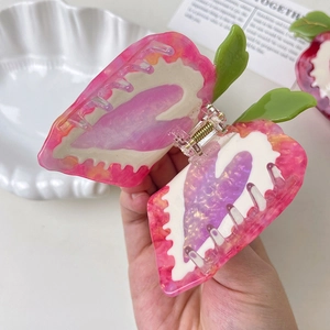 Close-up of strawberry hair claw clip made of marble texture acetate and metal spring