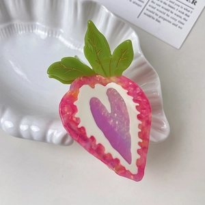 Close-up of a sweet strawberry-shaped hair claw clip with a glossy acetate finish