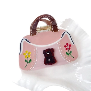 Pink acetate handbag-shaped hair claw clip with brown bear motif and sparkling rhinestones