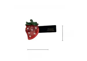Detail showing a 5.5cm x 3.7cm strawberry hair clip with green leaves and rhinestones