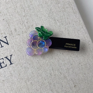 Detailed close-up of handmade grape hair clip with purple resin and France gold lettering