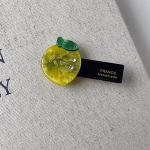 Detailed close-up of handmade lemon hair clip with yellow acetate and white rhinestones