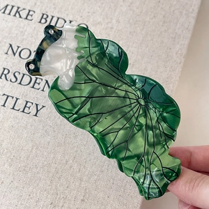 Vue détaillée d'une pince à cheveux feuille de lotus avec perles blanches et strass