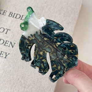 Détail de la pince à cheveux en acétate en forme de feuille avec motif marbre vert