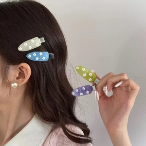 Dettaglio di fermagli per capelli in acrilico con fiori colorati indossati lateralmente