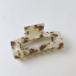 Macro detail of tortoiseshell acetate hair claw with iridescent purple accents