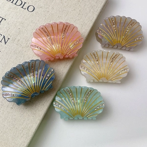 Elegant shell-shaped acetate hair claws with rhinestones and gold lines in five soft colors
