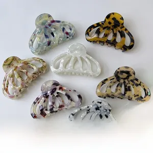 Detailed macro view of seven acetate claw clips with shell and marble patterns
