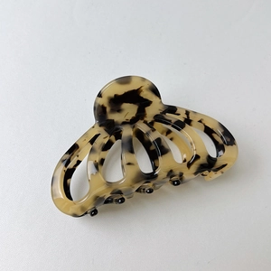 Detail view of tortoiseshell acetate claw clip showing hollow structure and metal spring