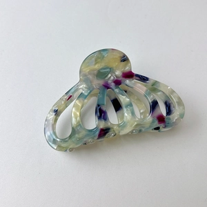 Macro view of marbled acetate hair claw clip with colorful hollow pumpkin design