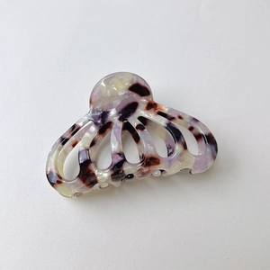 Macro shot of retro hollow acetate hair claw clip with purple and black tortoiseshell pattern