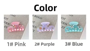 Détail de pinces à cheveux en acétate rose, violet et bleu avec fleurs et strass