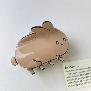 Gros plan d'une pince à cheveux lapin en acétate marron avec finition brillante et détails