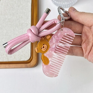 Porte-clés peigne en acétate avec ours à paillettes et cordon en cuir rose sur crochet