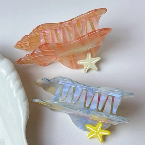 Detailed shot of ocean-themed hair claws in pink gradient and marble blue with starfish