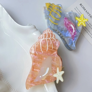 Ocean-themed shell and starfish hair claws in marble texture acrylic for summer styling
