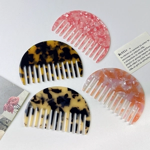 Set of four tortoiseshell acetate half-moon wide-tooth combs in stylish assorted patterns