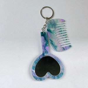 Détail de l'ensemble miroir coeur et peigne avec motif marbré bleu et vert