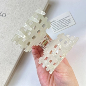 Detail of checkered hollow acetate hair claw clip with pearlescent white texture