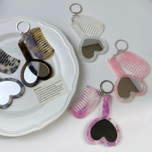 Détail du set porte-clés miroir cœur et mini peigne avec quatre motifs marbrés