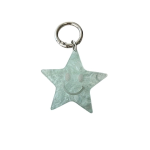 Mint green star keychain with marble pattern and smiley face on white background