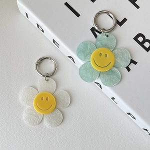 Detail of colorful acrylic flower keychains with smiley faces and silver metal clasps