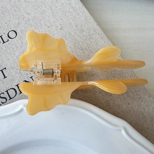 Detailed view of an amber acetate hair claw clip with a high-quality metal spring