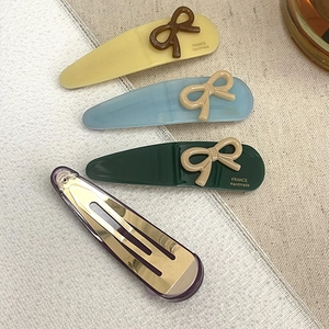 Set of colorful acetate bow hair clips in yellow, blue, and green with metal BB clips