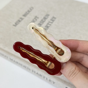 Hollow wave acetate hair clips in pearl white and deep red with gold duckbill clip