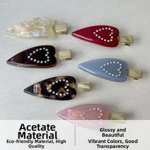 Dettaglio dei fermagli per capelli in acetato a cuore con strass in sei vari colori