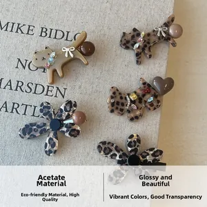 Detail of acetate leopard print hair clips in cat, dog, and flower shapes with rhinestones