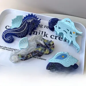 Detail of blue ocean-themed acetate hair claws featuring seahorse and jellyfish shapes