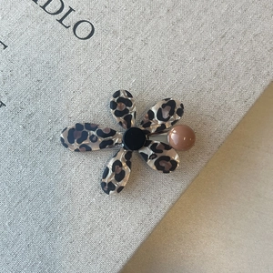 Close-up of leopard print flower hair clip with acetate petals and black center bead