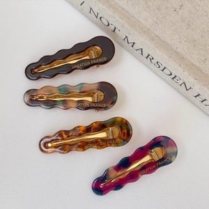 Set of four hollow wave-shaped acetate duckbill hair clips in assorted tortoiseshell colors