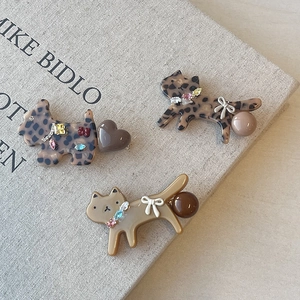 Leopard print cat and dog acetate hair clips with rhinestones on a vintage book cover
