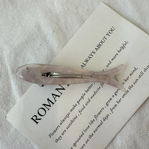 Macro shot of fish-shaped purple acetate hair clip with rhinestone and metal backing