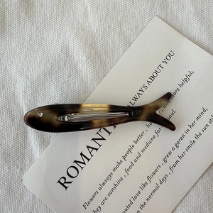 Detailed close-up of a fish-shaped acetate hair clip with classic tortoiseshell pattern