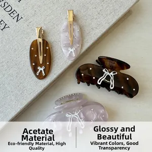 Close-up of tortoise and marble acetate hair clips with bow prints and crystals