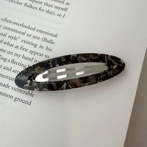 Detail of acetate hollow oval hair clip with classic tortoiseshell pattern and metal clip