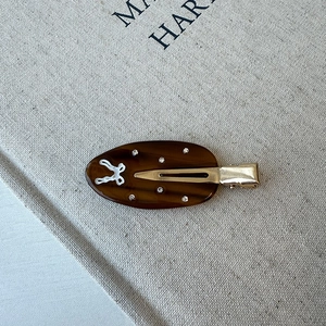 Macro shot of a tortoiseshell duckbill clip with rabbit inlay and sparkling rhinestones