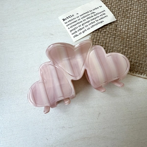 Detail of the pink marbled heart claw clip made of premium acetate for elegant hair styling