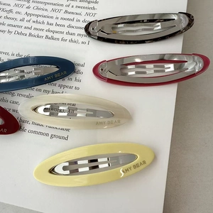 Oval acetate snap clips in tortoiseshell and solid colors on a vintage paper background
