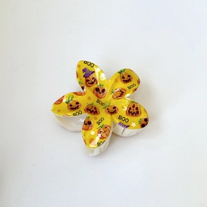 Détail d'une pince à cheveux fleur jaune avec motif citrouille d'Halloween et BOO