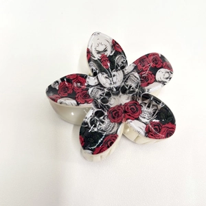 Détail d'une pince à cheveux fleur avec imprimé tête de mort et rose style gothique