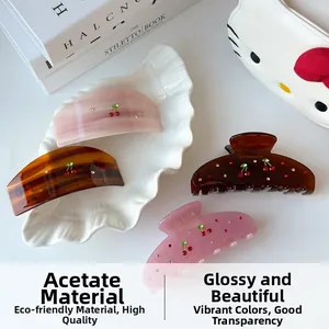 Detail view of acetate cherry hair claws with sparkling rhinestones in four colors