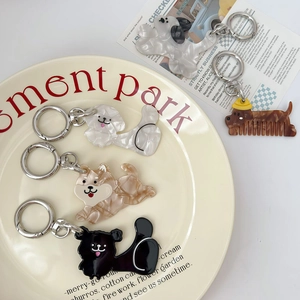 Artistic marble pattern dog-shaped acrylic keychains and comb charms on a plate