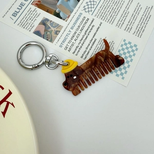 Detail of dachshund-shaped acetate hair comb keychain with tortoise shell pattern finish