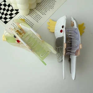 Top view of two colorful parrot hair claws in green and white acetate material