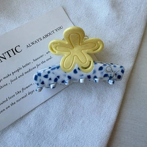 Pince à cheveux fleur avec motif floral jaune et base à texture marbrée bleue