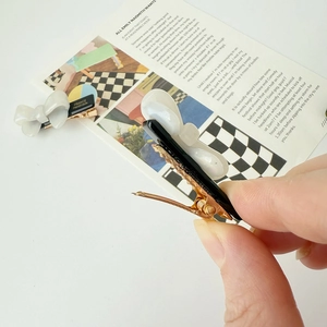 Detailed side view of the handmade acetate bow hair clip with gold metal duckbill clamp